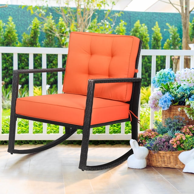 Gymax Chaise Berçante d'Extérieur en Osier pour Patio et Pelouse, Fauteuil Simple en Rotin à Bascule avec Coussin, Doté d'Un Cadre en Rotin PE Noir et de Coussins orange Vibrants. la Chaise Est Conçue au style Contemporain et Comprend un Coussin d'Assise Épais de 5 Pouces et un Coussin de Dossier de 3,5 Pouces pour le Confort. Elle a un Cadre Métallique Robuste d'Une Capacité de Charge de 360 Lb et Mesure 26,5 Pouces de Longueur, 36 Pouces de Largeur et 33 Pouces de Hauteur. la Chaise Berçante Est Présentée Placée sur