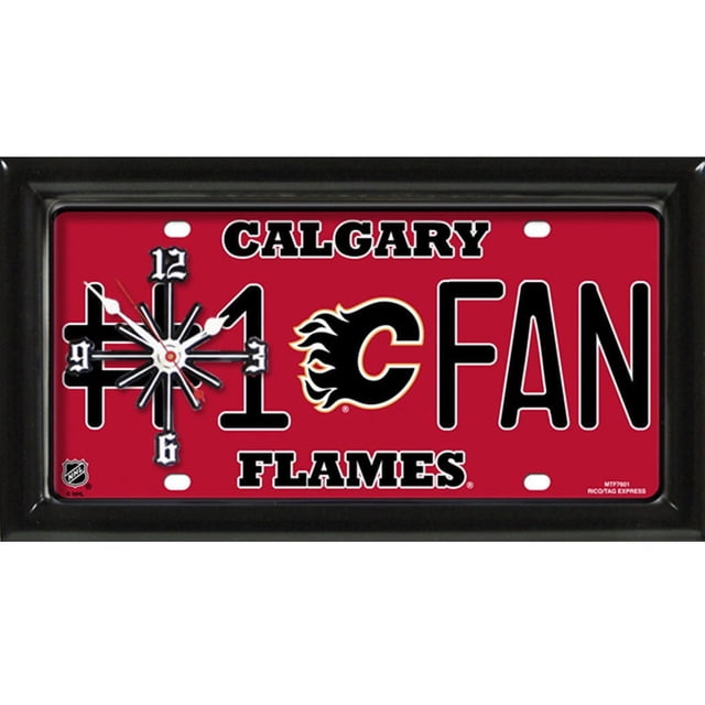 LNH Calgary Flames Horloge Murale Mesurant 7 par 13 Pouces avec un Cadre de 1 Pouce Fini Satin Noir. le design de Plaque d'Immatriculation Rectangulaire en Métal Présente un Arrière-Plan Rouge avec « #1 FAN » en Texte Noir et Blanc et le logo Calgary Flames flaming C Centré. le Cadran de l'Horloge sur la Gauche Comprend des Marqueurs d'Heure Noirs à 12, 3, 6 et 9, des Aiguilles Blanches des Heures et des Minutes, et une Trotteuse Rouge. « Calgary » et « Flames » Apparaissent au-Dessus