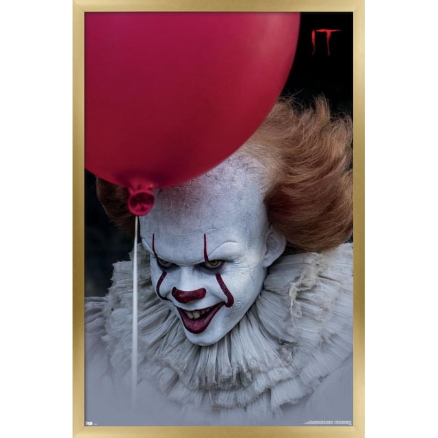 IT - Balloon Wall Poster, 14.725" x 22.375", depicting a close-up of Pennywise the clown with cracked white makeup, orange hair, and a layered ruffled collar, holding a red balloon against a dark background, printed on glossy paper suitable for wall art and party decoration.