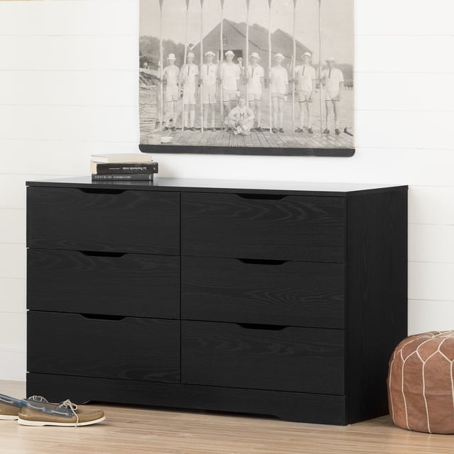 South Shore Holland Commode à 6 Tiroirs pour Adulte, Fini Chêne Noir, avec six Tiroirs Spacieux et Poignées Découpées, avec un Béquille Courbé, Positionnée contre un Mur shiplap Blanc avec une photo vintage en Noir et Blanc au-Dessus, un Plancher de Bois Franc en Dessous, et un pouf en Cuir Brun et des Chaussures Décontractées à Proximité.