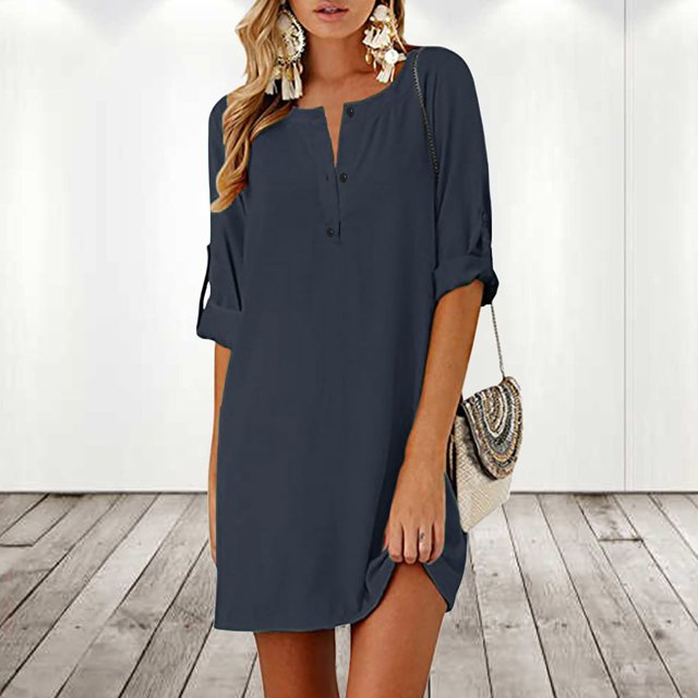 Pisexur Robe à Manches Courtes à Col Rond Longueur Genou pour Femmes de Couleur Unie Foncée. la Robe Présente une Encolure Ronde avec Détails de Boutons, des Manches Mi-Longues et un Ourlet Longueur Genou. Fabriquée en Mélange de polyester et d'Élasthanne, Elle Offre une Coupe Douce et Respirante. Convient aux occasions Décontractées, Quotidiennes Ou Spéciales au Printemps, en Été Ou en Automne. le Modèle Est Accessoirisé avec des Boucles d'Oreilles statement et un Sac à Main Tissé, Debout dans un Cadre Intérieur Minimaliste avec un Plancher de Bois.