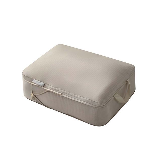 TopLLC Large Capacity Storage Bags, featuring a beige rectangular design with a zippered closure and a side handle for portability. Made of memory cloth, this multipurpose bag is ideal for travel, home storage, and organizing clothing, shoes, and toiletries. Its compression feature saves up to 40% space, making it suitable for dorms, RVs, and home offices.