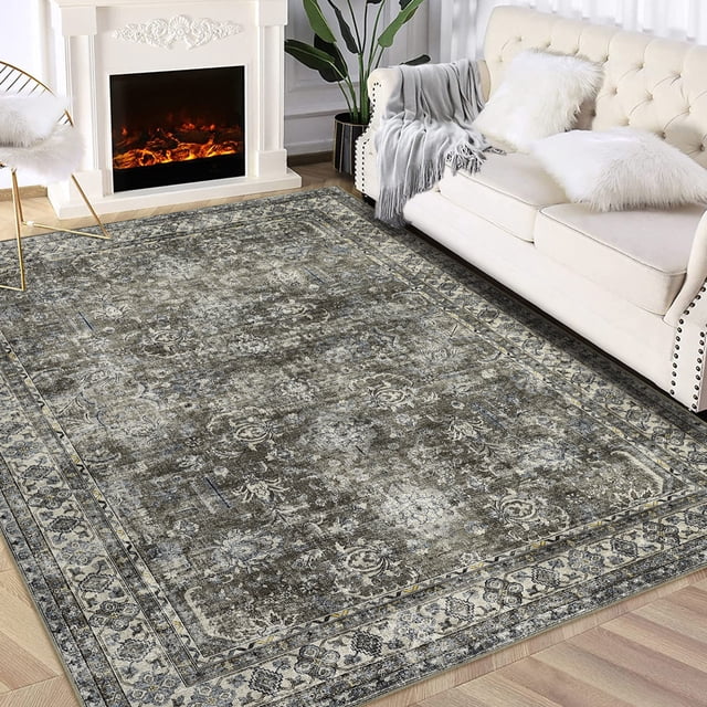 FairOnly Area Rugs 5'x7' machine washable rug with a floral vintage print pattern in brown and green. The rug is displayed in a living room setting with a fireplace, cream sofa, and wooden flooring. It features a thin construction with TPR backing for durability and non-slip functionality, making it safe for children, pets, and seniors. Suitable for living rooms, bedrooms, and dining rooms, this rug adds a modern, chic look to any space.