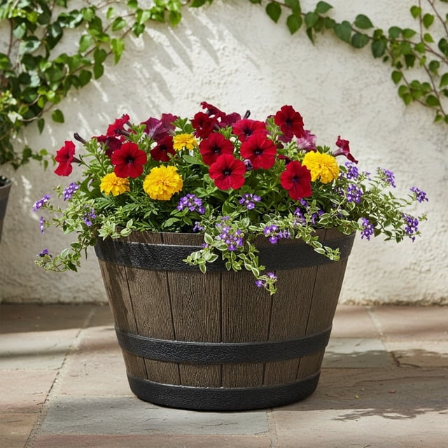Hometrends Jardinière en Résine de 14 Po en Forme de Baril de Whisky, Brun avec Bandes Noires, Fabriquée en Polyrésine Recyclée avec Revêtement Résistant aux Intempéries, Remplie de Pétunias Rouges, de Soucis Jaunes et de Petites Fleurs Violettes, Posée sur un patio en Pierre contre un Mur Blanc avec Lierre Vert, Convient pour l'Exposition au Jardin Ou comme Siège Intérieur Supplémentaire.