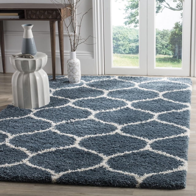 Safavieh Hudson Tapis Shag Géométrique Arline avec une Épaisse Peluche à Poils Longs Bleus et un Motif de Carreaux en Forme d'Oignon Blanc, Exposé sur un Plancher de Bois Franc Clair Près de Portes en Verre avec Lumière Naturelle, Stylé avec un Tabouret en Céramique Blanc et des vases Décoratifs, Convient pour Rehausser la texture dans les Espaces de Vie Modernes.