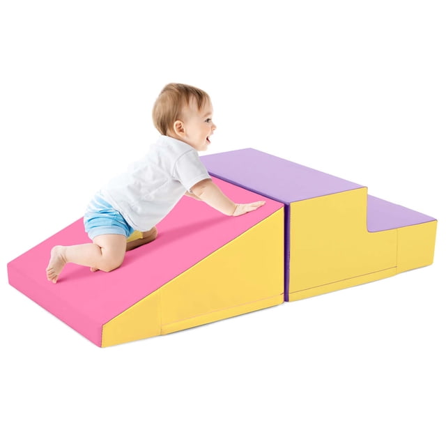 Costway Step and Slide Climber for Infants and Toddlers Baby Soft Foam Structure Blocks in yellow, designed for gross motor skill development and sensory play. The two-piece set includes a step and slide connected with hook and loop fasteners, made with high-density EPE foam and a waterproof PU leather cover. A toddler is shown climbing on the blocks, which are lightweight and portable for versatile play configurations.