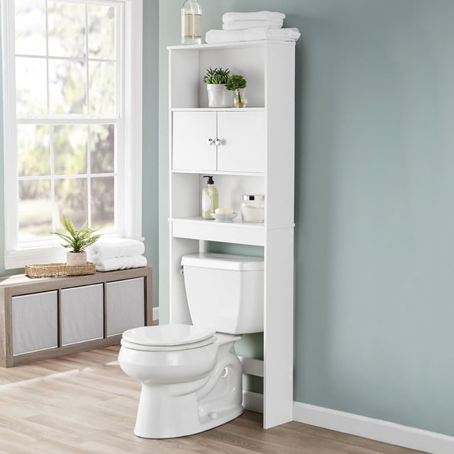 Zenna Home Économiseur d'Espace de Salle de Bain Classique à 3 Tablettes au-Dessus de la Toilette en Panneau de Particules Blanc avec Bords Finis et Boutons Chromés, Doté de Trois Tablettes Incluant une Armoire avec Porte Polyvalente, Positionné au-Dessus d'Une Toilette Blanche standard dans une Salle de Bain avec Murs Bleu Pâle et Plancher de Bois Clair, Convient pour Ranger le Linge, les Articles de Toilette et les Accessoires Décoratifs.