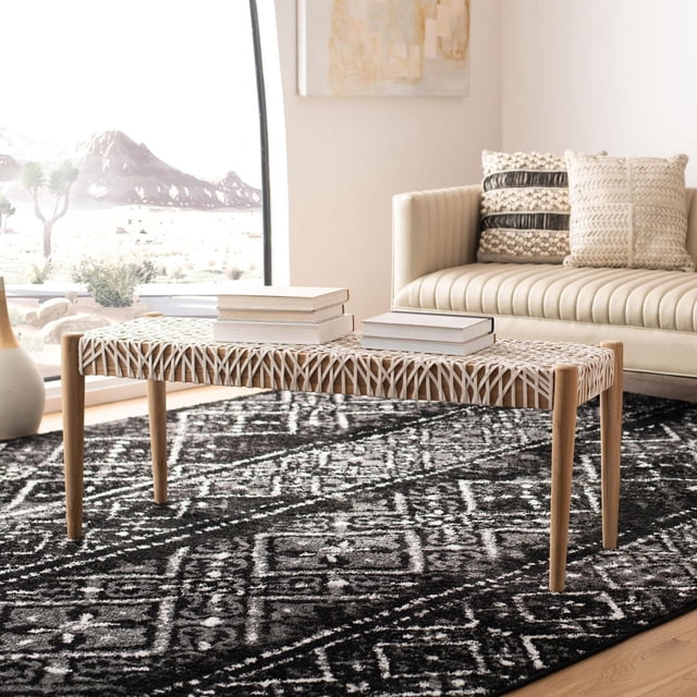 Safavieh Bandelier Cowhide Leather Bench with natural teak legs and off-white woven cowhide leather upholstery, set on a black and white geometric rug in a bright living room with a cream leather sofa and decorative pillows, suitable for extra seating or surface use.