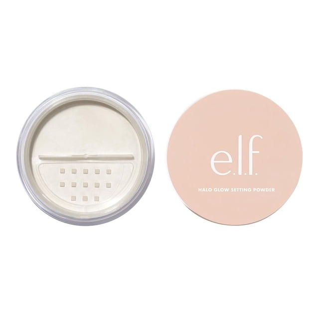 e.l.f. cosmetics Halo Glow Poudre Fixatrice dans un Contenant Rond Transparent avec un Tamis Montrant une Poudre Blanche Finement Moulue, à Côté d'Un Couvercle Pêche Mat avec le logo e.l.f. et le Nom du Produit, Conçue pour Offrir une Finition Douce et Illuminatrice avec des Particules de Saphir Synthétique pour le Contrôle de la Brillance.
