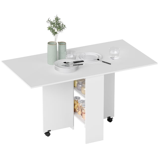HOMCOM Table à Manger Pliante, Table à Abattants avec Étagères à 2 Niveaux en Panneau de Particules Blanc. Cette Table de Cuisine Gain de Place Présente un design à Abattants avec les Deux Côtés Allongés, Pouvant Accueillir jusqu'à six Personnes. Deux Étagères en Dessous Offrent un Rangement Discret pour Pots, Tasses et Autres Articles. des Roues Freinées sur les Panneaux Latéraux Permettent un Pliage et un Expansion Pratiques. la Table Est Conçue avec des Assiettes, des Couverts et des vases Décoratifs.