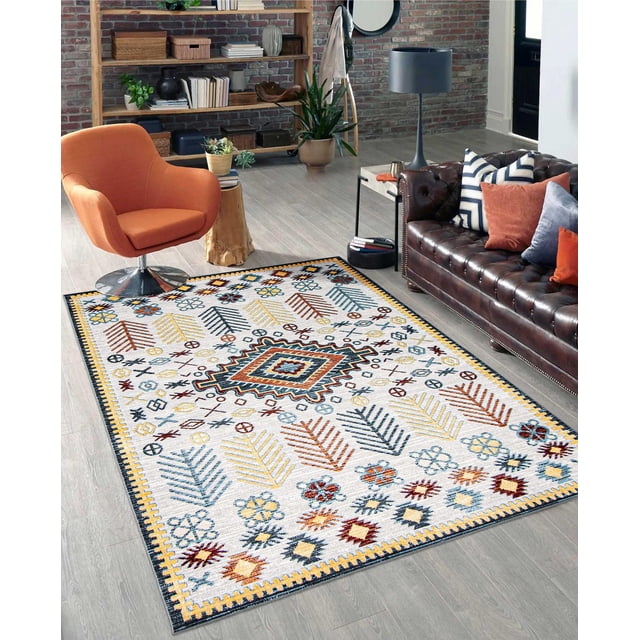 ECARPET Washable Southwestern Area Rug & Runner for Hallway, Living Room, Bedroom with low pile, machine washable polyester in grey featuring detailed southwestern geometric and floral patterns in blue, yellow, rust, and burgundy. Placed on light wood flooring in a living room with an orange swivel chair, dark brown leather tufted sofa with cushions, wooden side table, and black floor lamp, this durable, stain-resistant rug suits high traffic areas and adds warmth to modern interiors.