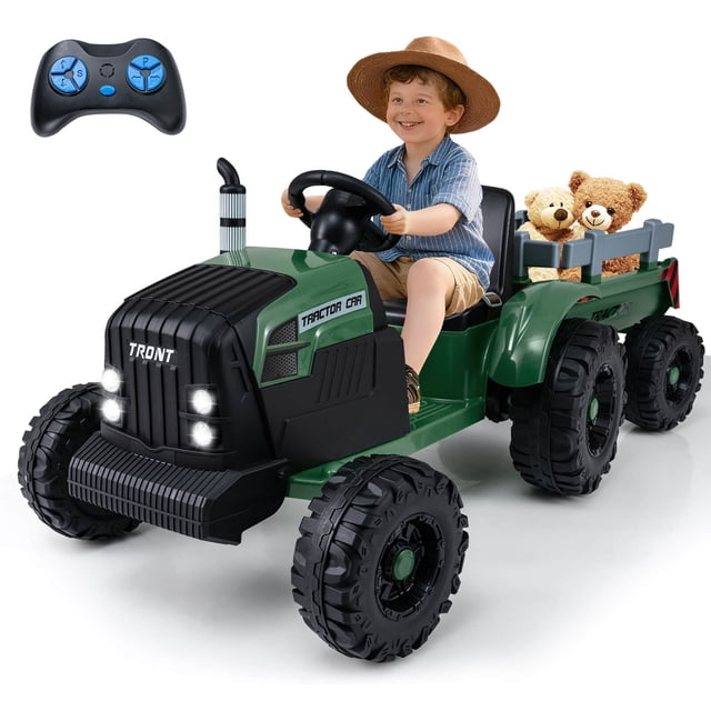 Costway 24V Ride On Tractor for Kids with Detachable Trailer in dark green, featuring six anti-slip wheels, LED headlights, and a simulated chimney. A child is seated on the wide seat with a safety belt, driving the tractor while two stuffed animals are placed in the detachable trailer. Includes a remote control for parental guidance and dual control modes for manual or remote operation. This powered ride-on electric vehicle is designed for kids aged 3-8 years, suitable for various terrains and slopes up to 15 degrees.