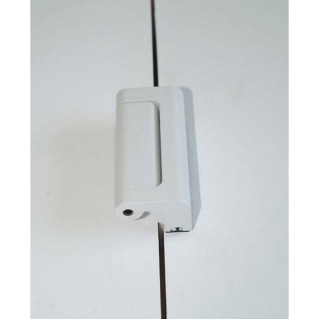 The Door Guardian inside home security lock mounted on a white door jamb, showing a close-up front view of the compact white plastic lock designed for easy engagement, childproofing, and deterring forced entry in baby proofing.