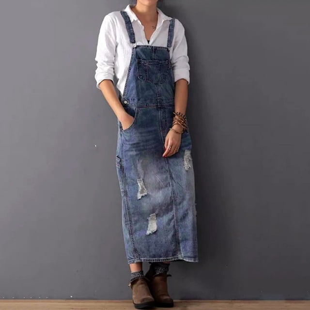 FcBaudy Robe Camis Sans Manches à Col Rond, Robe Décontractée en denim pour Femme Sans Manches avec Fermeture Éclair en Coton. la Robe Présente un design à Col Rond, une Coupe Sans Manches et une Fermeture Éclair, Offrant un style Décontracté et Confortable Adapté à l'Été. l'Image Montre un Modèle Portant une Robe en denim avec des Détails Usés, Assortie d'Une Chemise Blanche en Dessous et de Bottines Brunes, Debout sur un Fond Gris Uni.