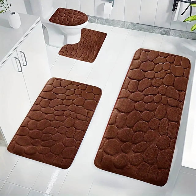 Dvkptbk Coffee Bathroom Rugs Bath Mat Set 4 Pieces shown in a bathroom setup. The set includes memory foam bath mats in a coffee brown textured design, featuring non-slip backing and absorbent material. Includes a toilet mat, U-shaped mat, and two rectangular mats, all machine washable and ideal for bathroom decor and keeping floors dry and comfortable.