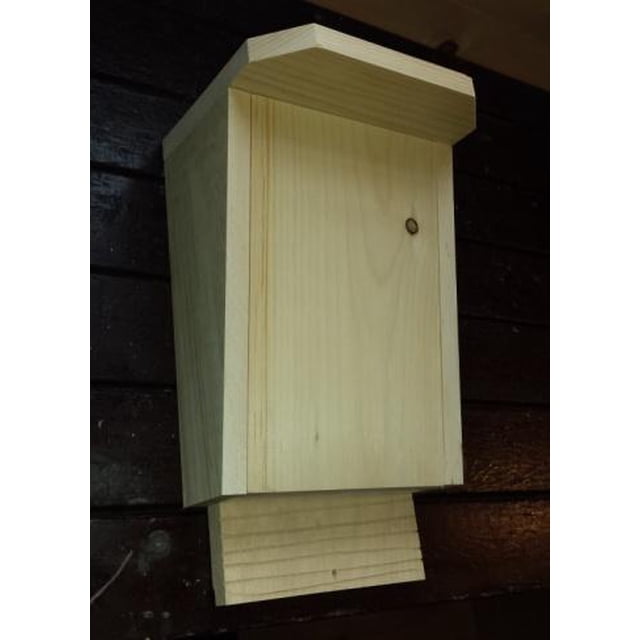 Urban Nature Store Pine Bat House Kit, a build-it-yourself bat house made from white pine, shown fully assembled. The bat house features a natural wood finish with a slanted roof and grooved landing pad for easy bat access. Finished dimensions are 14 ½ inches high, 8 ¾ inches wide, and 7 ¼ inches deep. Ideal for natural pest control by attracting mosquito-eating bats. Handmade in Canada.