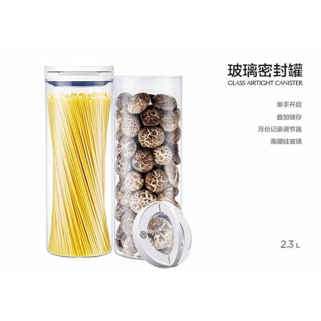 Anya Ensemble de Contenants Hermétiques en Verre Borosilicaté Élevé 2,3 L à l'Épreuve de l'Humidité pour une Main Comprenant Deux Contenants en Verre Transparent, l'Un Rempli de spaghetti Jaunes et l'Autre de Champignons Séchés, Tous Deux Scellés avec des Couvercles Blancs Hermétiques Incluant des Cadrans de Calendrier Intégrés pour des Rappels de Rangement, Parfait pour l'Organisation de la Cuisine et l'Entreposage des Aliments à l'Épreuve de l'Humidité.