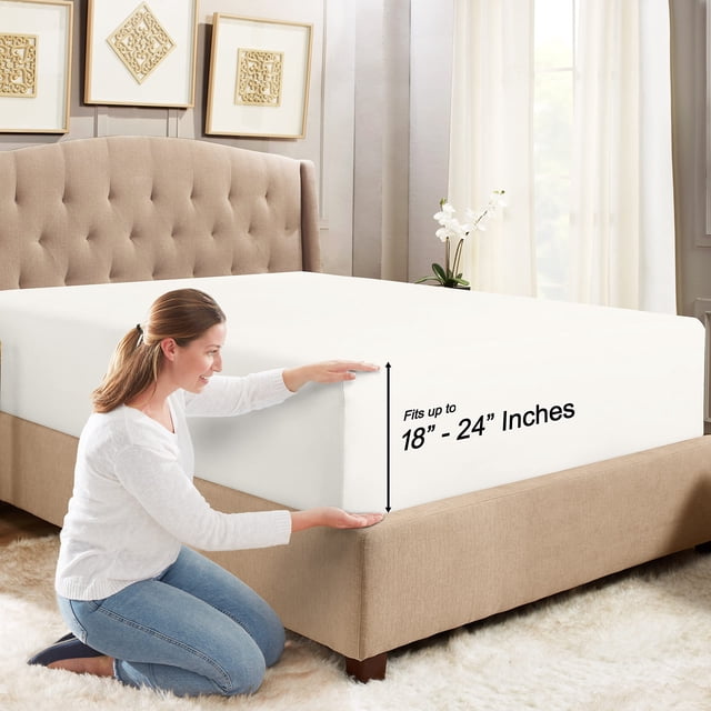 Empyrean Bedding King Fitted Sheet in white, crafted for luxury bedding with deep pockets to fit mattresses up to 24 inches deep. The ultra-soft, fade-resistant sheet includes corner straps for a secure fit. Displayed on a king-size bed in a modern bedroom setting with beige upholstery and decorative accents.