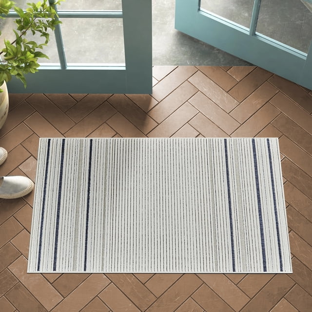 Rug Branch Maise Abstract Indoor Outdoor Area Rug, Cream Blue, 2'7" x 4'11" modern rectangular runner with thin vertical stripes in cream, blue, and beige on polypropylene with jute backing, placed on brown herringbone tile floor near open teal doors and a plant, suitable for entryway, kitchen, or as a doormat.