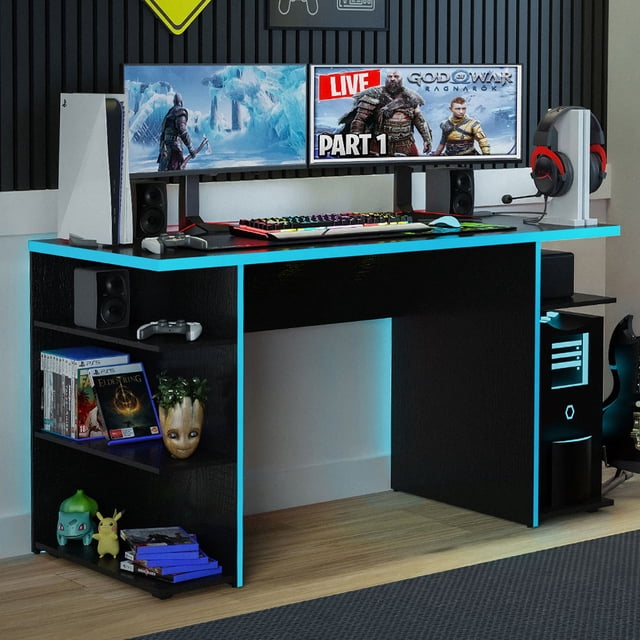 Madesa Large Modern Gaming Computer Desk, 53 inches, in black and blue finish, featuring a spacious tabletop with ample room for a keyboard, dual monitors, mouse, and speakers. The desk includes five open shelves for storage and display of gaming accessories, books, and decor. Designed with cable management holes for organized wiring, it is made from high-quality particle board with a durable finish. Suitable for gaming, studying, or home office use, the desk is shown in a modern gaming setup with accessories and decor.