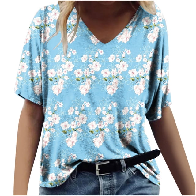 T-shirts Graphiques pour Femmes Mode pour Femmes Impression Décontractée Col en V Manches Courtes T-Shirt Ample Hauts. un T-Shirt Bleu Pâle à Manches Courtes Col en V Présentant une Impression Graphique Florale avec des Fleurs Blanches et Roses. le T-Shirt Est Style Ample et Assorti à des jeans en denim et une Ceinture Noire, Idéal pour une Tenue Estivale Décontractée Ou des Sorties Quotidiennes.