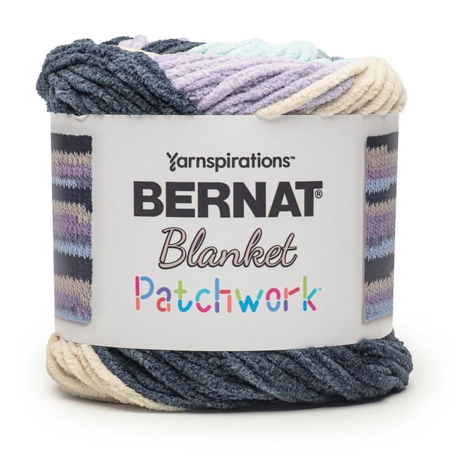 Bernat® Blanket Patchwork™ #6 Super Bulky Polyester Yarn in a chenille texture with patchwork stripes of dark gray, lavender, cream, and light blue, wrapped with a label showing the brand and yarn name, suitable for knitting and crochet home decor projects.