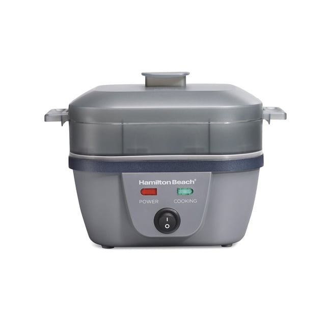 Hamilton Beach Egg Bites Plus Electric Egg Cooker in grey with translucent lid, front view showing power and cooking indicator lights and black on/off switch, compact small appliance ideal for cooking eggs in multiple styles.