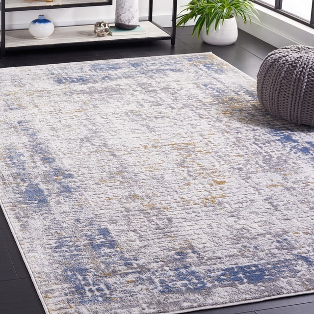 SAFAVIEH Palma Cooper Oriental Area Rug featuring a distressed traditional pattern in blue, grey, and beige tones, power loomed with soft synthetic yarns for durability, displayed on dark hardwood flooring near a grey knitted pouf and a white planter with green foliage, suitable for enhancing modern accent rug décor.