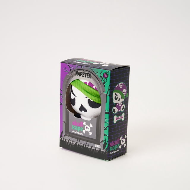 Skull Kapz Plush Napzter in a purple and green collectible box with a tombstone window, featuring a white skull plush wearing a green headband and purple skull-patterned cap, part of the Skull Kapz dead dapper plush toy series for ages 6 and up.