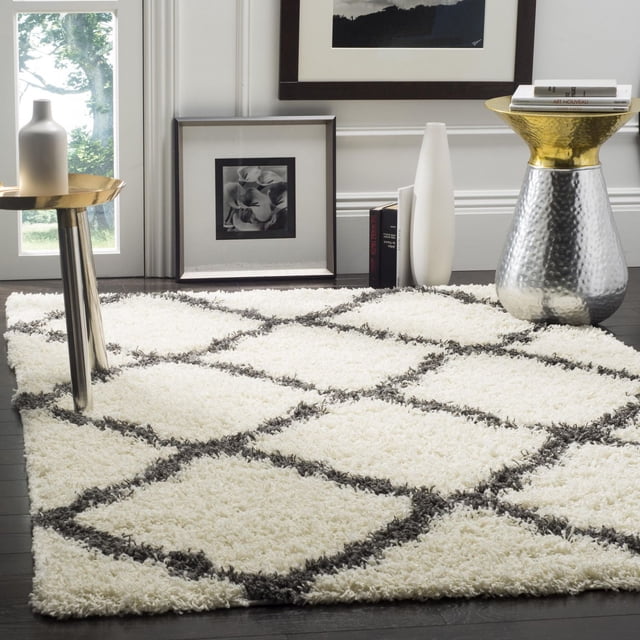 Safavieh Dallas Tapis Shag Géométrique Logan pour Aire avec Motif de Carreaux Marocains Ivoire et Gris Foncé sur une pile Shag en Polypropylène Pelucheuse, Montré sur Plancher de Bois Franc Foncé avec tables d'Accent Métalliques et Décor Minimaliste, Idéal pour Ajouter une texture Douce et un style Moderne aux Intérieurs de la Maison.