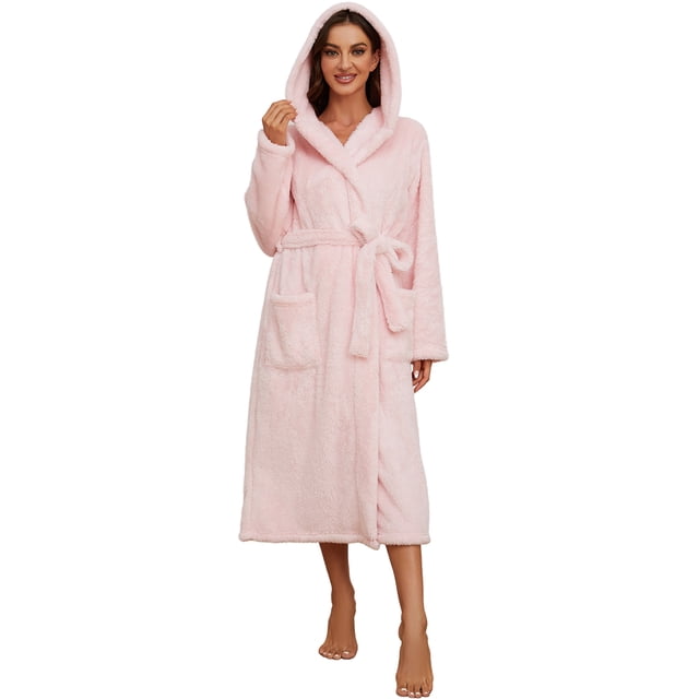 HEARTNICE Womens Hooded Fleece Robe in light pink, size L-XL. This long, fluffy, thick, and warm plush bathrobe features a hooded design for added warmth, two large front pockets for convenience, and adjustable inner and outer ties for a secure fit. Made from soft, long fur fleece fabric, it is ideal for lounging, post-shower relaxation, or staying cozy during cold winter days. The robe extends to mid-calf and is shown in a front-facing view.