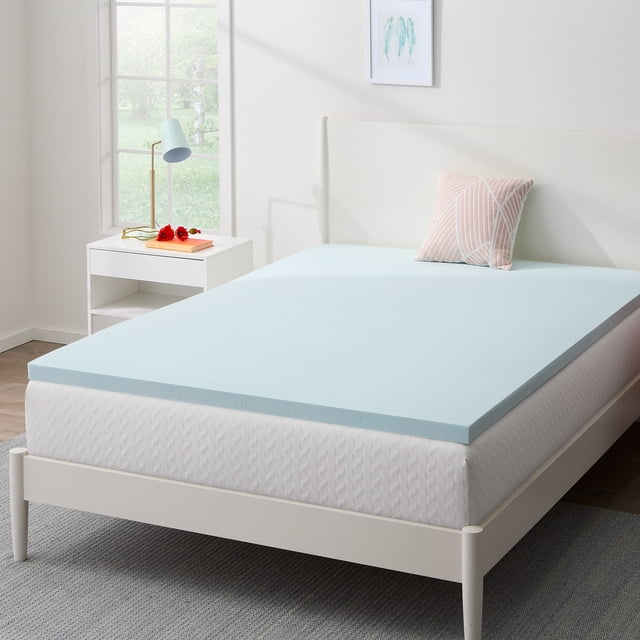 Homestay Surmatelas en Mousse Mémoire Infusée de Gel de 2 Pouces, avec infusion de Gel Rafraîchissant et certification CertiPUR-US, Affiché sur un Lit Format Simple dans une Chambre Lumineuse. le Surmatelas Bleu Pâle Repose sur un Matelas Blanc avec une Housse Texturée. la Chambre Comprend une Table de Nuit Blanche avec une Lampe et une Déco, et une Fenêtre Surplombant la Verdure.
