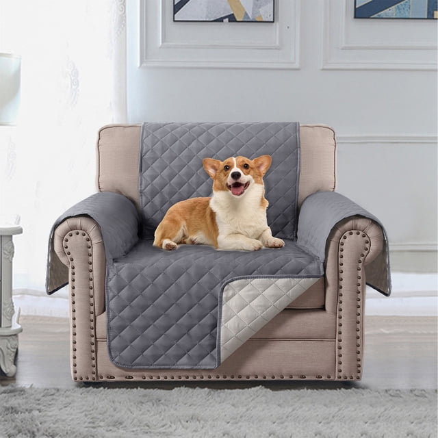 Sofa Cover Chair Cover Chair Cover Chair Sofa Protector Slip Sofa Cover for 1 Cushion Chair Furniture Protector by Czzoypi, shown in a quilted gray design with a reversible light gray underside. The cover is displayed on a beige armchair with a small dog sitting comfortably on it. The setting is a bright living room with a white wall, decorative artwork, and a soft gray rug.