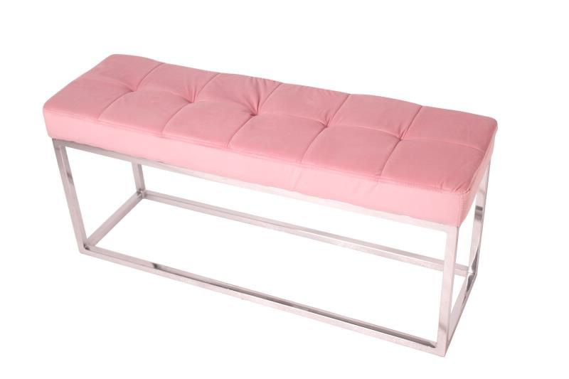 Banc rembourré en velours vert avec base en acier inoxydable.