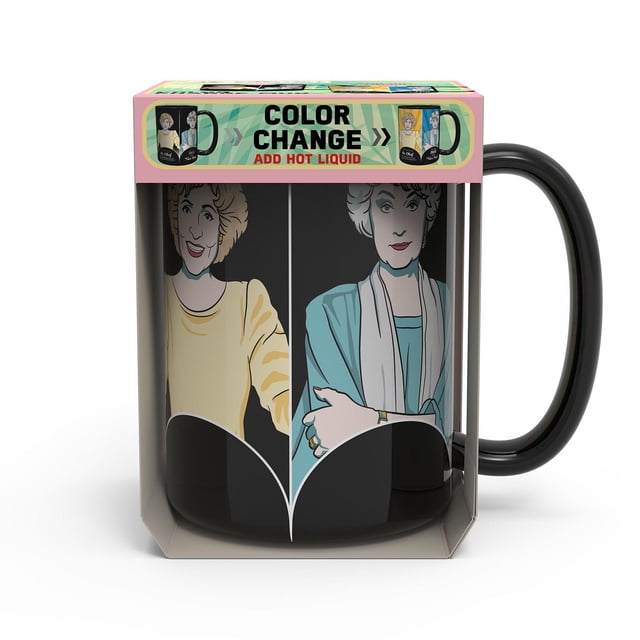 Zak Designs Golden Girls 15oz colour change mug with black ceramic body featuring two illustrated characters in yellow and teal outfits, packaged to show it reveals new artwork when filled with hot liquid, suitable for coffee or tea.