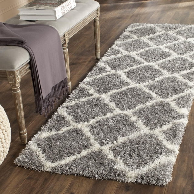 Safavieh Montreal Tapis Shag Géométrique Cebrail avec une Peluche à Motif de Losanges Gris et Blanc, pile Shag sur Plancher de Bois Franc Foncé, à Côté d'Un Banc en Bois avec un Jeté Gris et des Livres, Convient pour Ajouter de la texture et de la Chaleur aux Intérieurs Contemporains Ou Transitionnels.