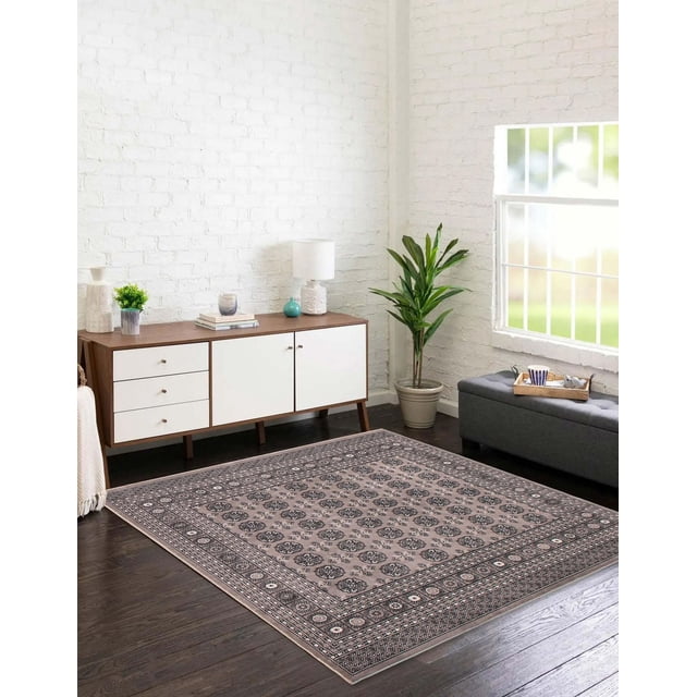 Tekke Oriental Area Rug for Living Room, Dining Room, Bedroom in grey with symmetrical oval and diamond-shaped motifs and a detailed border pattern, placed on dark hardwood floors in a bright room with white brick walls. The rug complements a mid-century modern sideboard with white doors and wood top, a potted green plant, and a grey upholstered bench with a tray holding a cup and teapot. Suitable for adding traditional elegance and soft texture to living spaces.