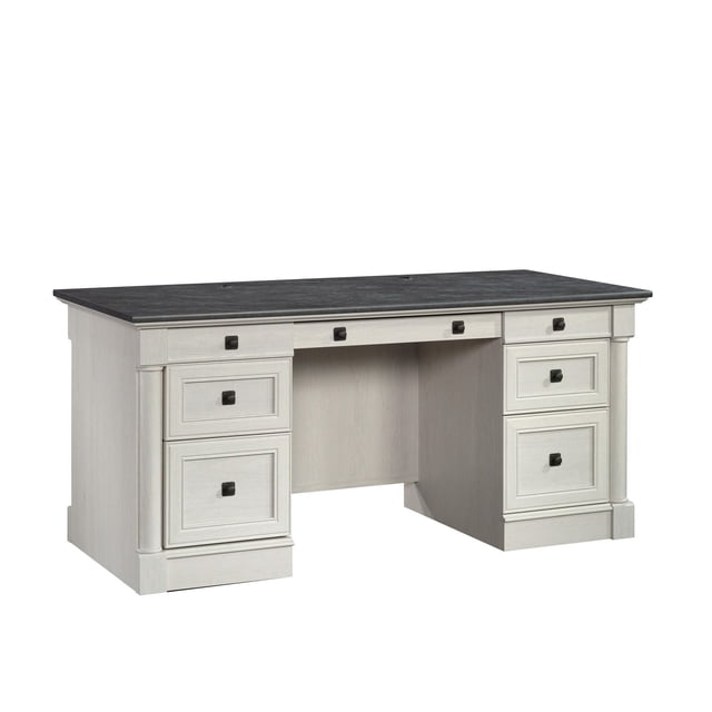 Sauder Palladia® Executive Desk featuring a classic design with framed panel doors, pilasters, and contoured bases. Includes a large drawer with a flip-down panel for keyboard/mouse, two pencil drawers, two storage drawers, lower file drawers with full extension slides for letter, legal, or European size files, and a cord management system. Finished in a light tone with a contrasting dark desktop and square metal hardware.