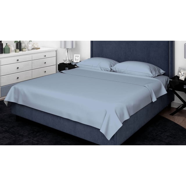 Johnson Home 500 Thread Count Cotton Sheet Set Sky Blue (Queen) on a queen bed with a navy upholstered headboard. The set includes a wrinkle-resistant, breathable cotton flat sheet, fitted sheet with elastic edges, and two pillowcases in sky blue. The heavyweight cotton fabric is double brushed for softness and fits deep mattresses securely. The bedroom features a white dresser and black nightstands with lamps and decor. This sheet set is also suitable for year-round comfort and guest rooms.