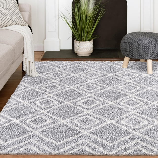 Gaelen Tapis Tissé Gris et Crème avec un Motif Treillis en Losanges Moelleux en Ivoire sur Gris Poussiéreux, Exposé dans un Salon avec un sofa beige, Jeté Blanc, pouf Tricoté Gris avec Pattes en Bois, et une Plante Verte en Pot sur un Foyer Noir, Convient pour Rehausser la Déco Maison Moderne avec un Confort durable.