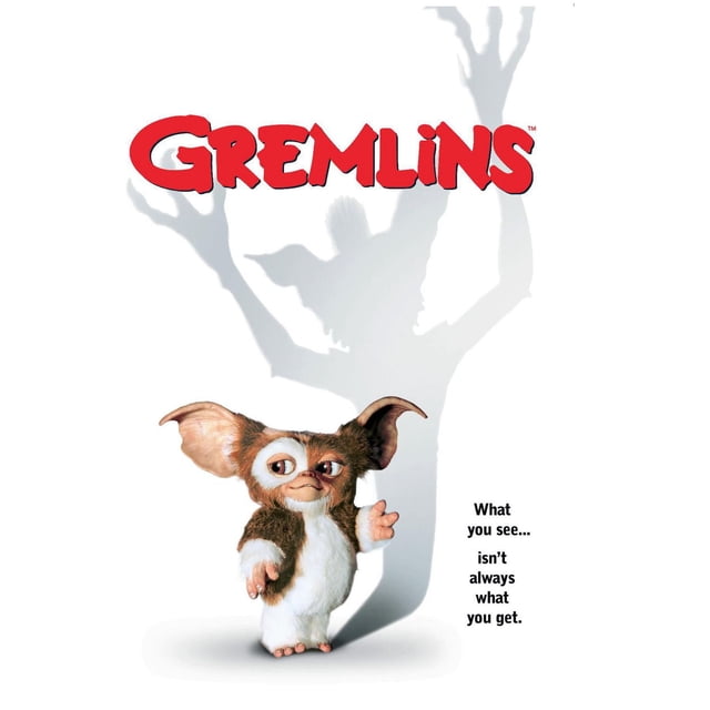 Gremlins - One Sheet Wall Poster, 22.375" x 34" showing Gizmo, a small brown and white furry creature with large ears, standing with one hand raised. Behind him is a shadow of a larger gremlin with clawed hands raised. The red Gremlins logo is at the top, with the phrase 'What you see... isn't always what you get.' on the right. This glossy poster is suitable for decorating bedrooms, offices, or dorm rooms.