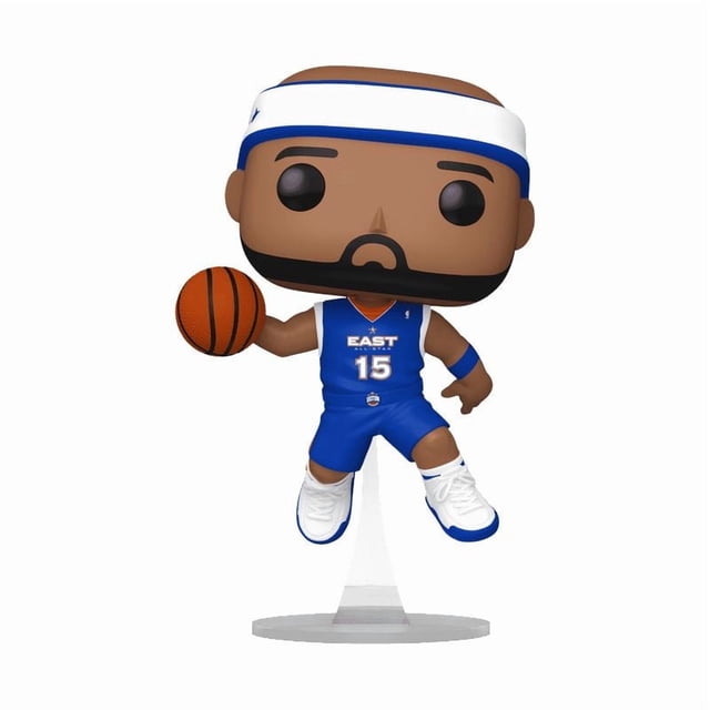 Funko Pop! NBA: Vince Carter in 2005 All Star Uniform Vinyl Figure showing a stylized vinyl figure of Vince Carter wearing a blue East All Star basketball uniform with number 15, white headband, and white sneakers, holding a basketball in his right hand, posed mid-air on a clear display stand, suitable for NBA fans and vinyl figure collectors.