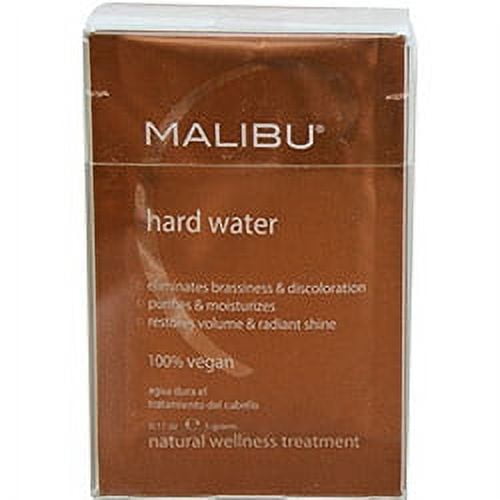 Malibu C Hard Water Weekly Demineralizer 12 Pack, displayed in a brown box with white text highlighting its benefits, including eliminating brassiness, restoring shine, and being 100% vegan. Formulated to remove buildup like iron and lime from hair, it is suitable for hard water environments and preparing for colour treatments.