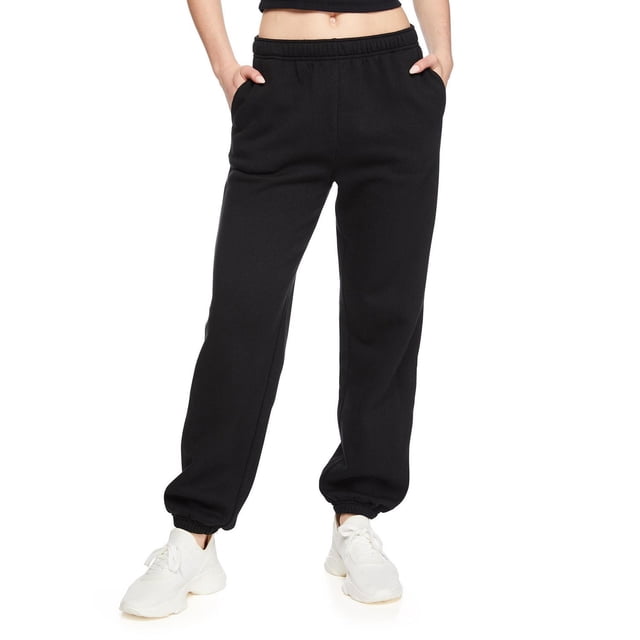 No Boundaries Women's Oversized Jogger in black fleece knit with elasticized waistband and drawstring, two on-seam pockets, and elasticized cuffs, styled with white sneakers, suitable for casual athleisure wear or relaxed home comfort.