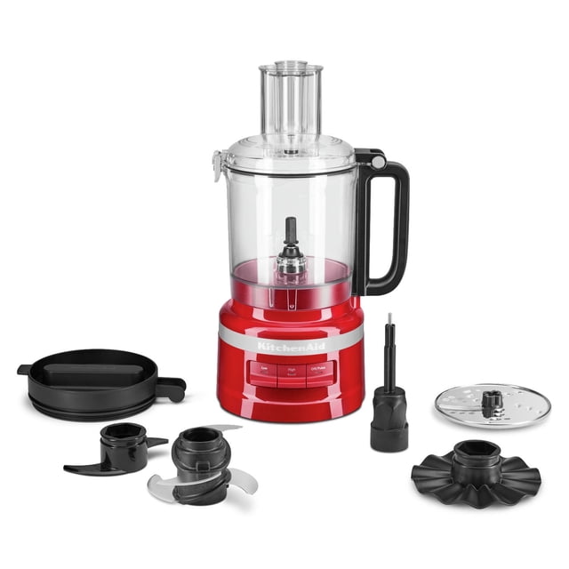 KitchenAid® 9 Cup Food Processor in red with clear 9-cup work bowl and black handle, featuring three speed options on the base. Includes black lid with 2-in-1 feed tube, multipurpose four blade for chopping and mincing, dough blade for kneading, whisk accessory for whipping, reversible slicing/shredding disc, and refrigerator lid for storage, all arranged on a white background. Suitable for processing tougher ingredients and mincing meat quickly.