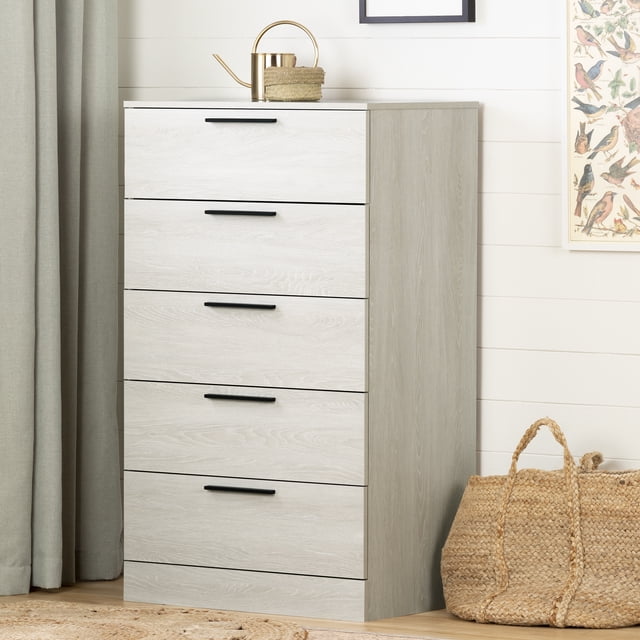 South Shore Step One Essential 5-Drawer Chest for Adult in winter oak finish, featuring a modern tall design with five drawers and narrow black metal handles, ideal for bedroom storage that saves floor space, shown with a woven basket and framed bird artwork in a neutral room.