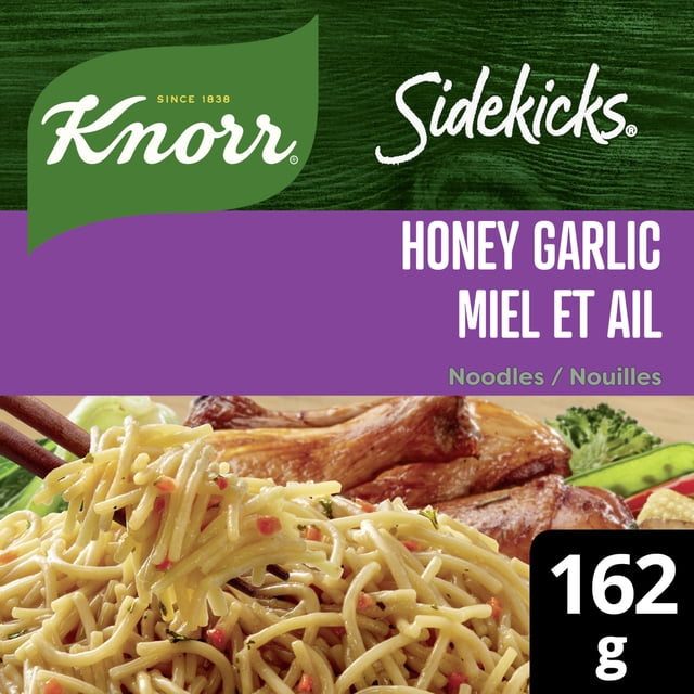 Knorr Sidekicks Nouilles au Miel et à l'Ail, Emballage Montrant des Nouilles Cuites de Style Vermicelle avec des Flocons de Piment Rouge et des Herbes, Tenues par des Baguettes, Servies avec du Poulet Rôti et des Légumes, avec une Étiquette de Poids de 162 g.