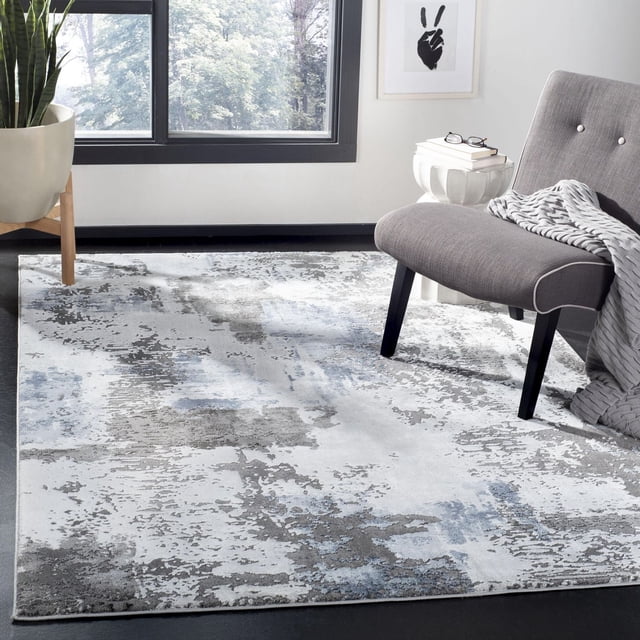 SAFAVIEH Tapis d'Aire Abstrait Constantine avec un design Rectangulaire et des Motifs Abstraits Tourbillonnants dans des Tons Gris, Bleus et Blancs. Fabriqué avec des Fils Synthétiques Doux et un Fin Poil Gravé, Il Est Placé sous une Chaise d'Appoint Grise avec des Pattes Noires, à Côté d'Une table d'Appoint Blanche avec des Livres et des Lunettes, Près d'Une Grande Fenêtre et d'Une Plante en Pot. le Tapis Convient Aussi pour Rehausser les Salons Contemporains Ou les Espaces de Bureau.