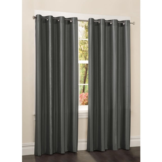 Mainstays Faux Silk Drapery Grommet Window Curtains Panel in dark grey, hanging on a metal rod with silver grommets. The semi-sheer polyester fabric with subtle sheen measures 54 inches wide and 84 inches long, partially covering a window with outdoor greenery. Ideal for room darkening and easy installation on standard curtain rods, also suitable for refreshing home window coverings.