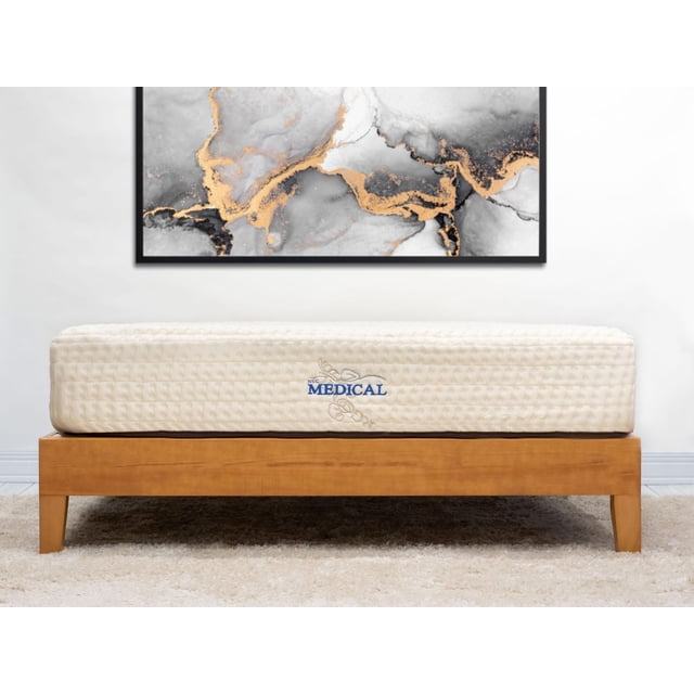 NSC Medical Éléments Matelas en Latex à Naturels Montré sur un Profil Latéral Centré sur un Cadre de Lit en Bois, Présentant une surface Matelassée beige Pâle avec le logo Bleu NSC Medical, Fabriqué avec du Latex 100 % Naturel pour un Soutien Ferme, un Soulagement des Points de Pression, et une Housse en Coton Biologique Régulateur de Température et en Laine Joma, contre un Mur Blanc avec des Oeuvres Abstraites Noires, Grises et Dorées.
